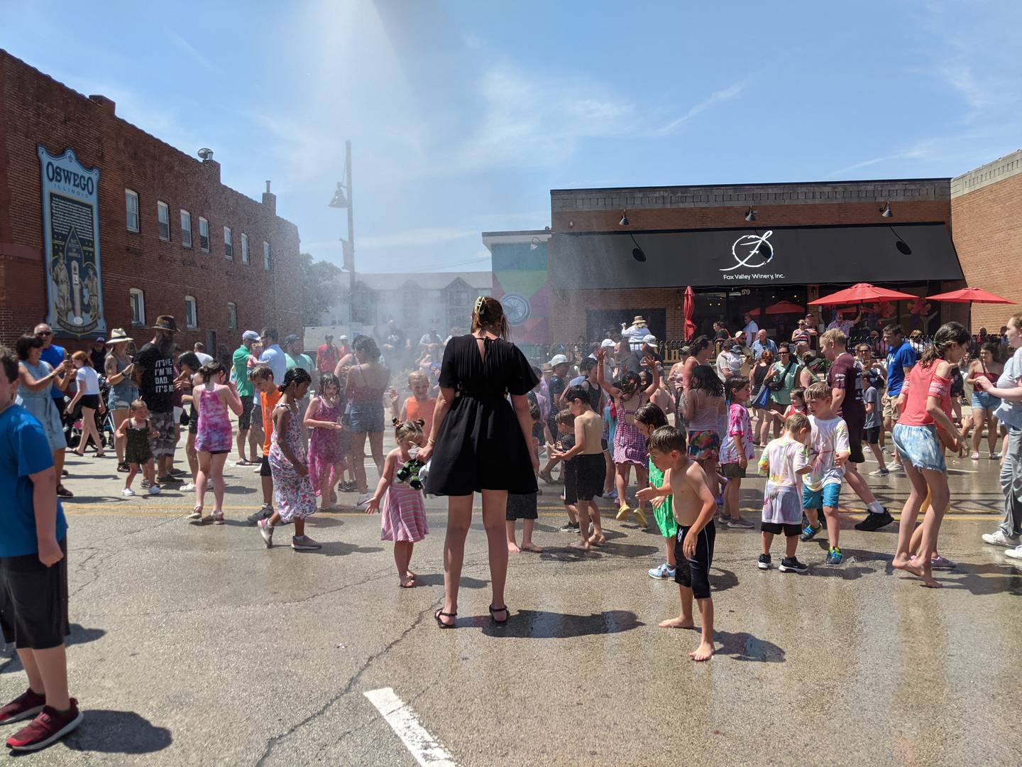 To cool off those who had been watching the PrairieFest Parade on June 16, Oswego firefighters used one of their fire trucks to spray water on the crowd.