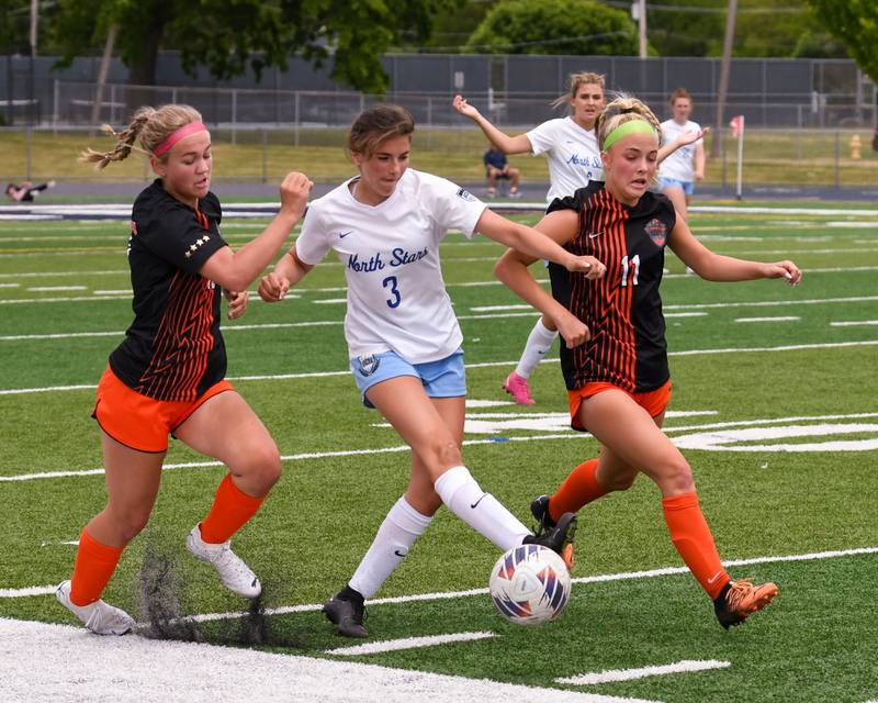 St. Charles North Abigail Sims (3) gets defended by St. Charles East Taum Smith, left, and teammate Ella Stehman (11) on Saturday May 27th during the sectional title game held at West Chicago Community High School.