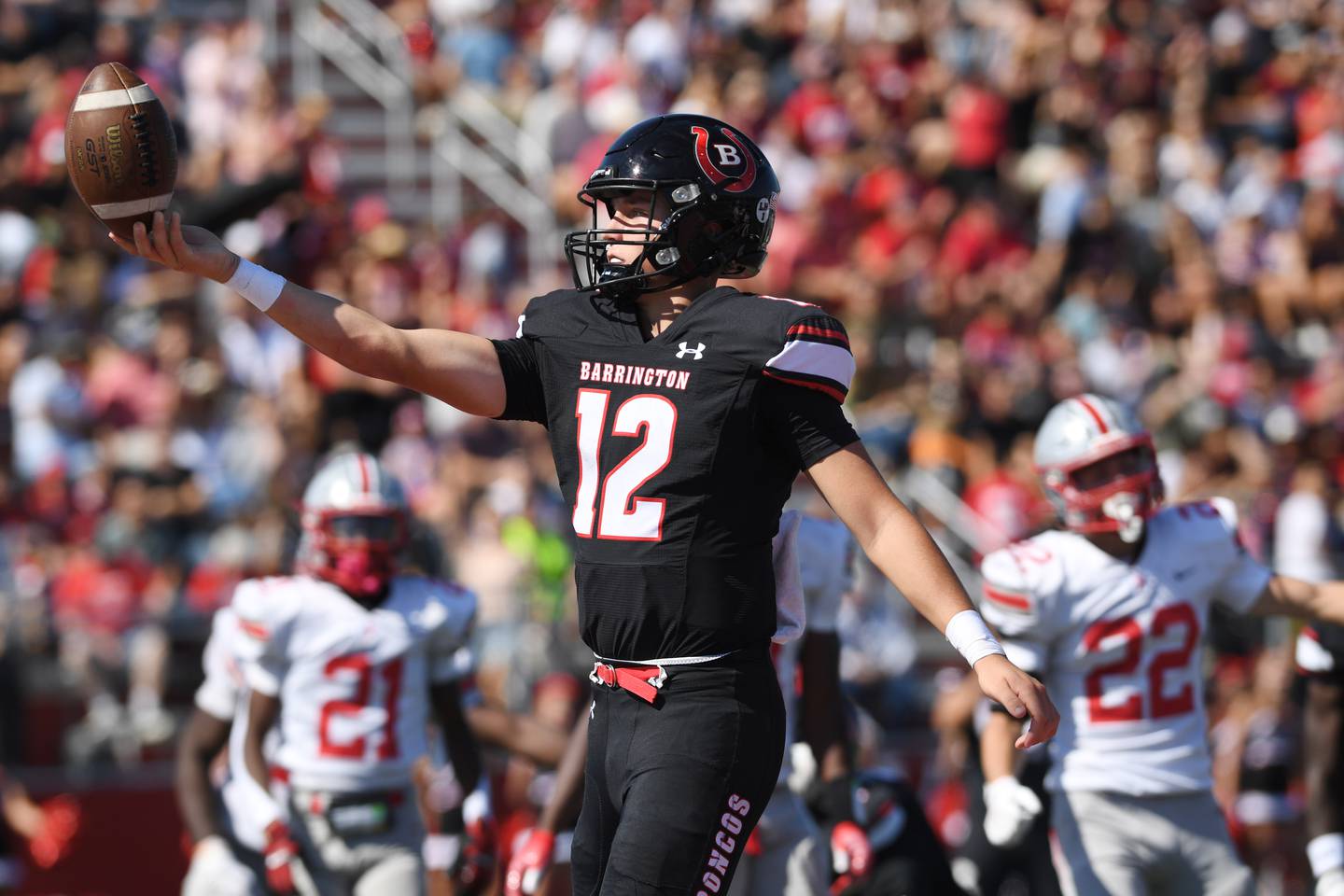 Barrington quarterback Luke Tepas balances the ball on his fingertips before flipping it, while scoring a touchdown in the closing seconds of the second quarter of Saturday’s game against Palatine.