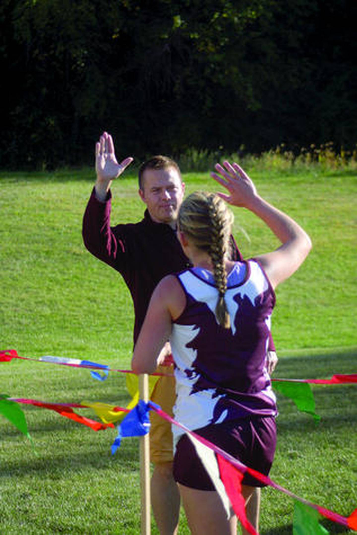 Morris girls cross country runner Bridget Gile gets set to high-five Redskins coach Joe Blumberg during Tuesday's Chief dual held at home against Sandwich.