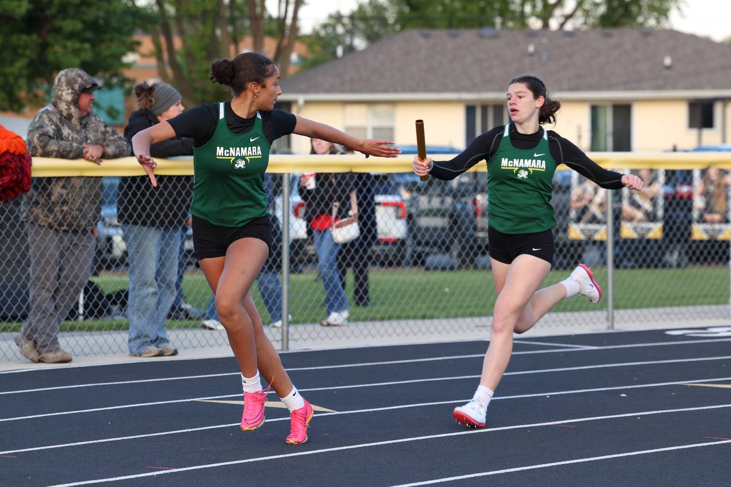Bishop McNamara's Trinitee Thompson receives the handoff from Dylan Pallissard during the 4x200 relay race at the Herscher Track Invite on Friday, May 1, 2026.