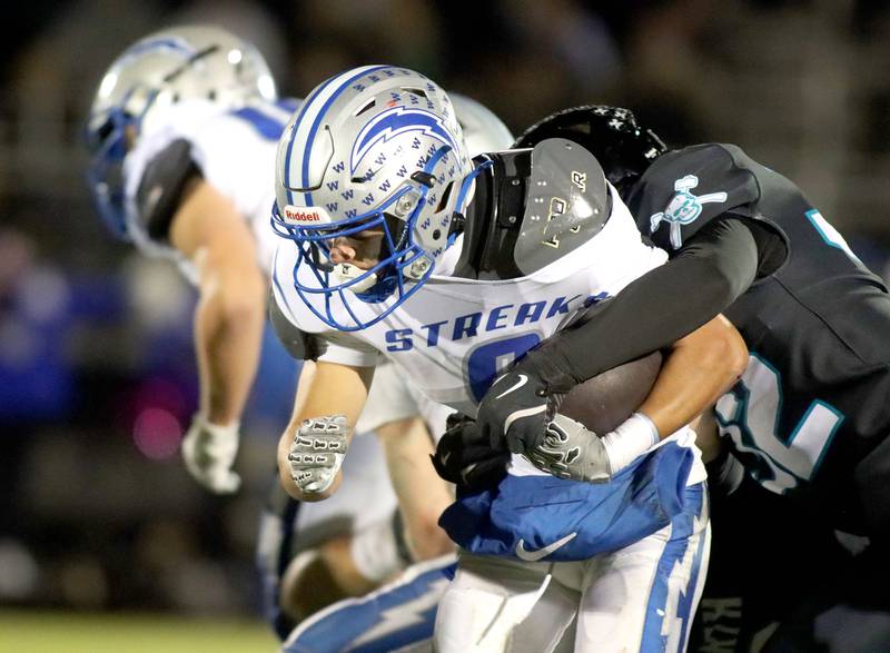 Woodstock’s Matthew Cress is brought down by Woodstock North’s Jackson Burris in varsity football at Woodstock North High School on Friday, October 24, 2025.