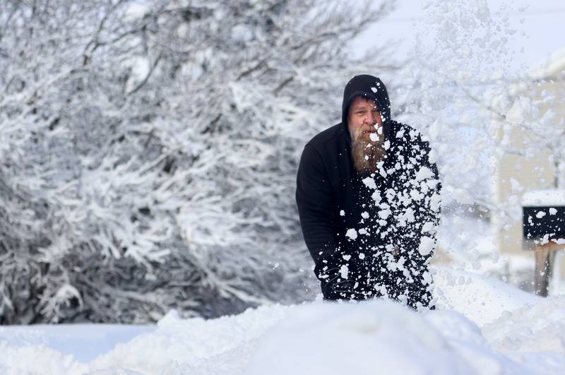Roman Dolezel clears his Woodstock driveway Saturday in the wake of overnight snow. Bitter cold is expected to worsen into Sunday, the National Weather Service warned.