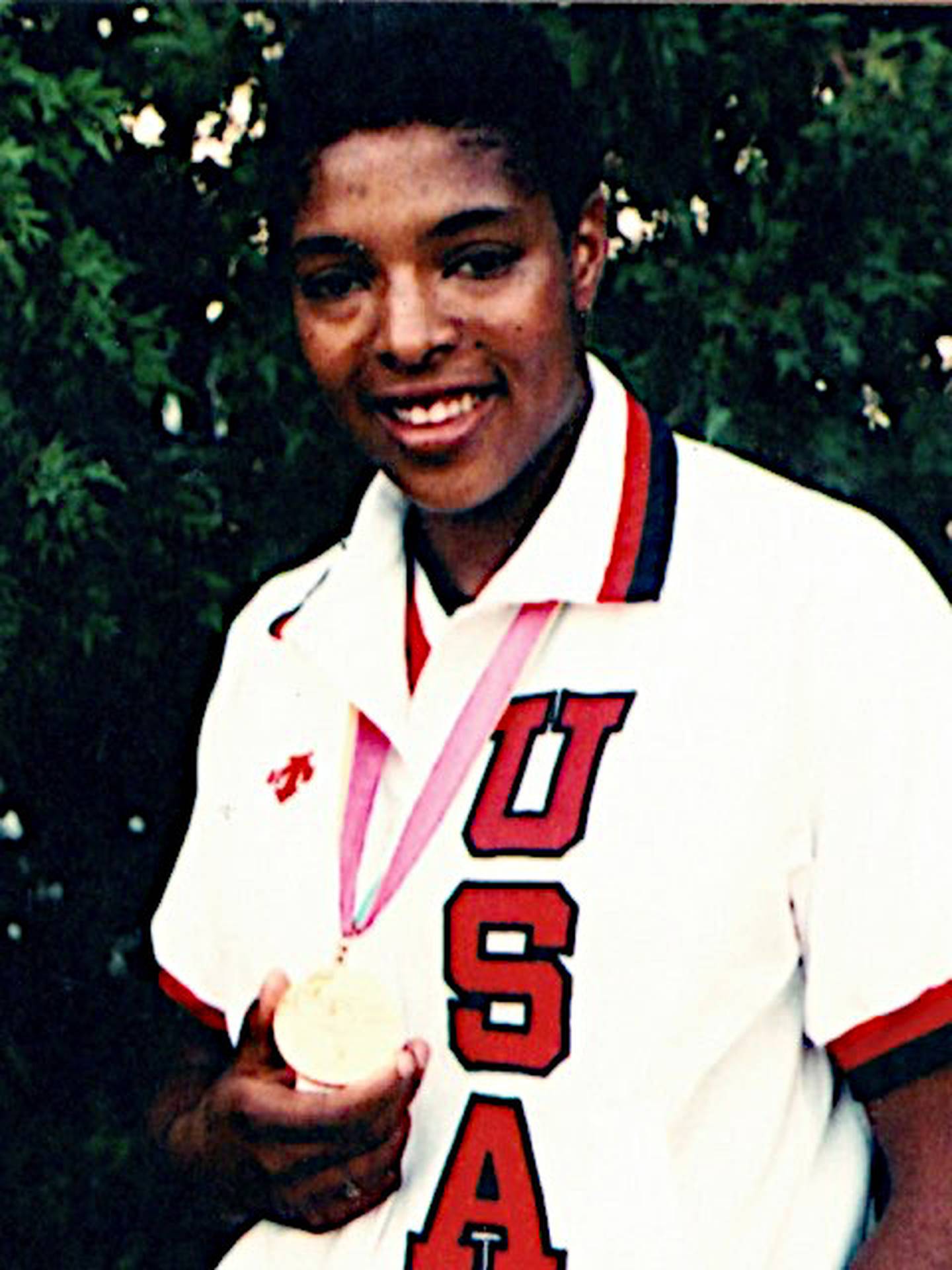 Joliet West graduate Cathy Boswell shows off the gold medal she won as a member of the USA Women's Basketball Team in the 1984 Summer Olympics.