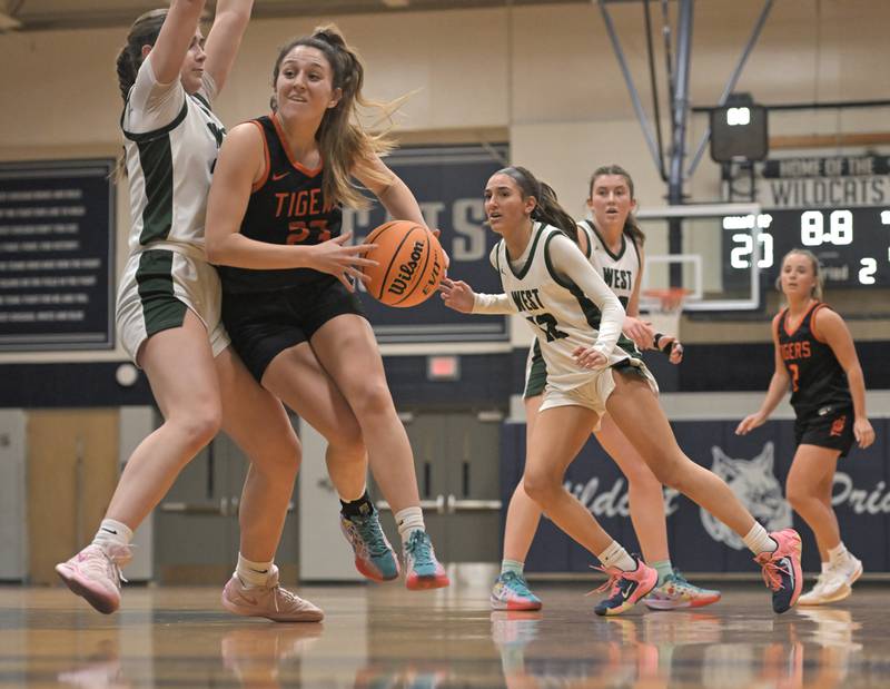 Wheaton Warrenville South’s Shea Carver works toward the basket against Glenbard West’s Ellie Noble in a regional final girls basketball game in West Chicago on Friday, Feb. 21, 2025.