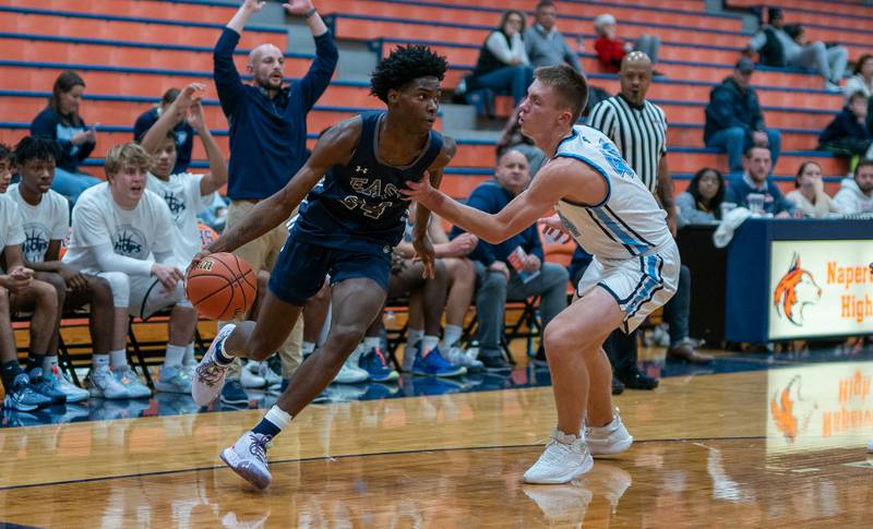 Oswego East's Mekhi Lowery (24) drives the baseline against Downers Grove South's Justin Sveiteris (44) during the hoops for healing basketball tournament at Naperville North High School on Monday, Nov 21, 2022.