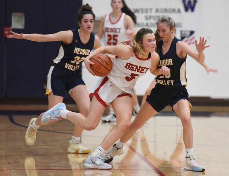Benet's Lenee Beaummont (5) is pressured by Neuqua Valley's Tia Poulakidas (32) and Kylee Norkus during Tuesday’s IHSA Class 4A regional semifinal girls basketball game in Aurora.