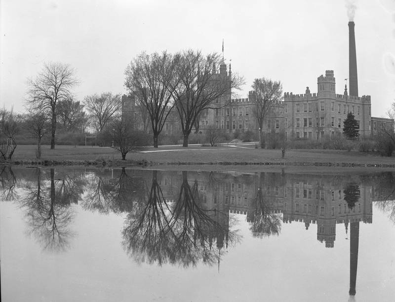 Altgeld Hall is reflected in the lagoon on the campus of Northern Illinois State Teachers College (now NIU) in 1940.