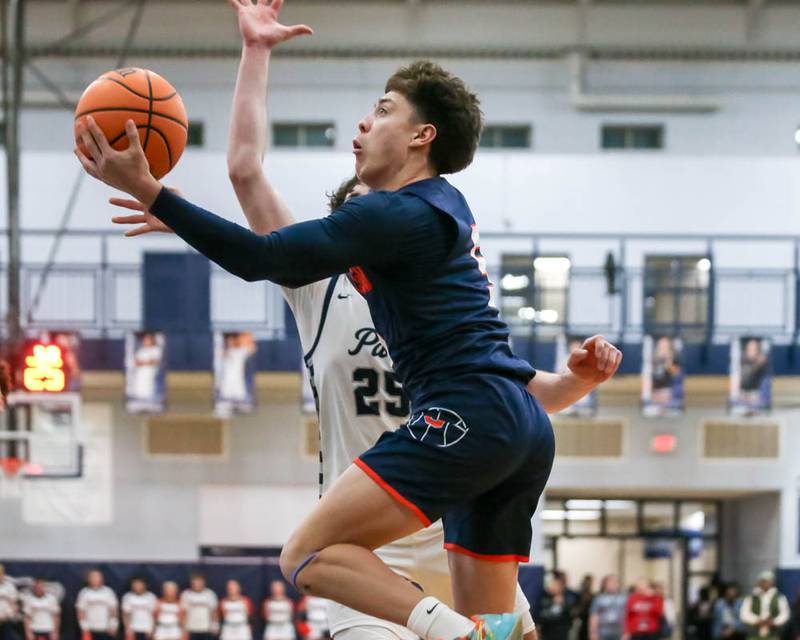 Oswego's Mariano Velasco (5) drives to the basket during their basketball game between Oswego at Oswego East, Feb 13, 2026 in Oswego.