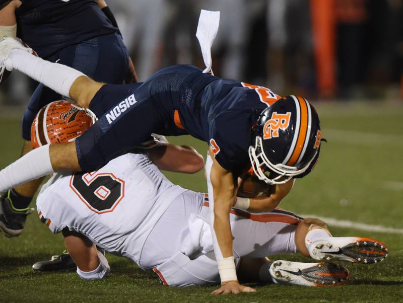 Joe Lewnard/jlewnard@dailyherald.com
Buffalo Grove quarterback Payton Diaz, top, gets sacked by Hersey’s Logan Farrell during Friday’s game in Buffalo Grove.