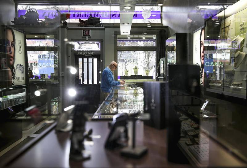 Frank Kula, co-owner of Kula Jewelry & Loan, sorts through mail Tuesday in downtown Joliet. Kula said he remembers when Chicago Street was open.