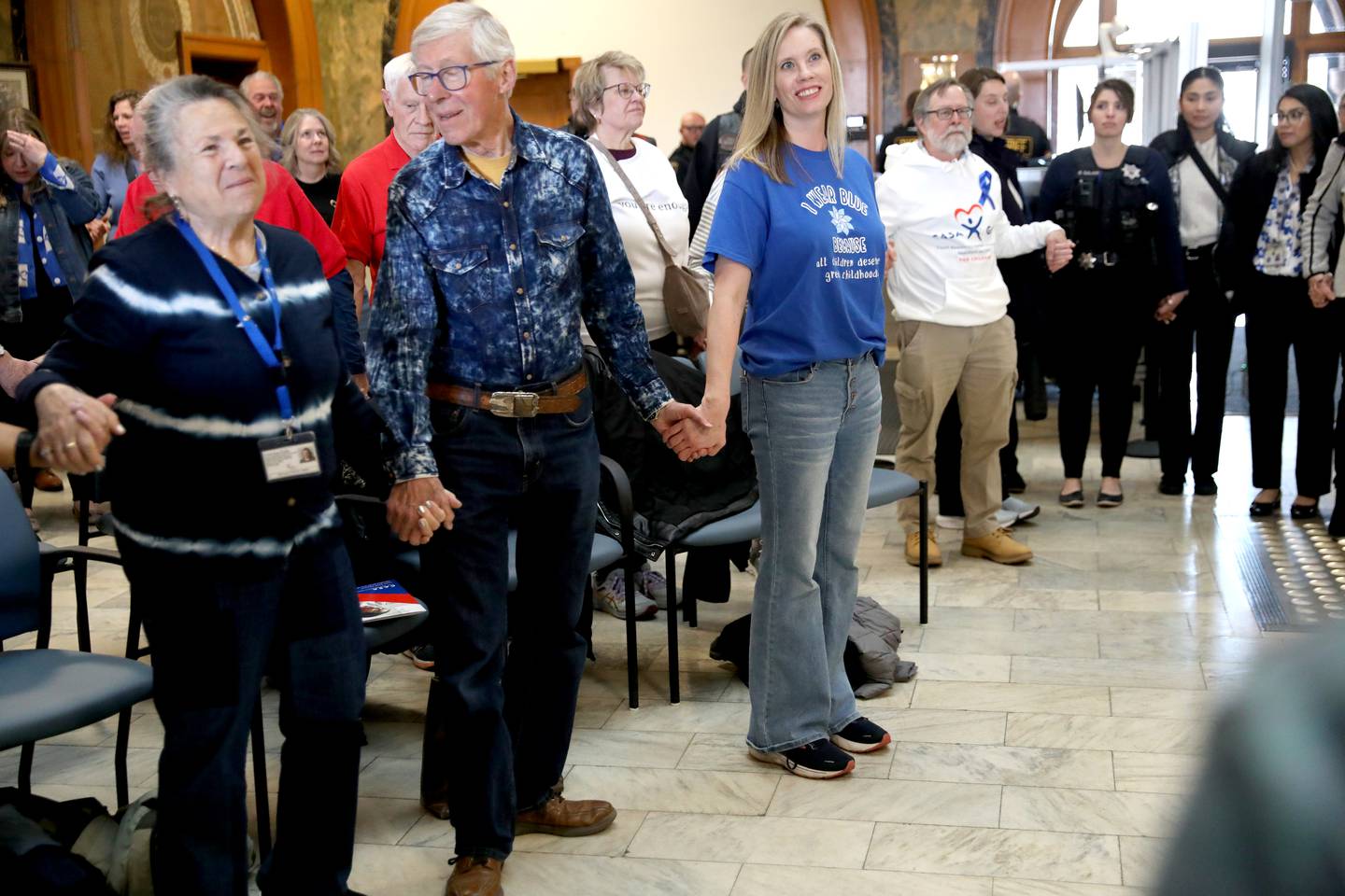 Participants join hands during the annual Hands Around the Courthouse in honor of National Child Abuse Prevention Month on Thursday, April 10, 2025 at the Kane County Courthouse in Geneva.