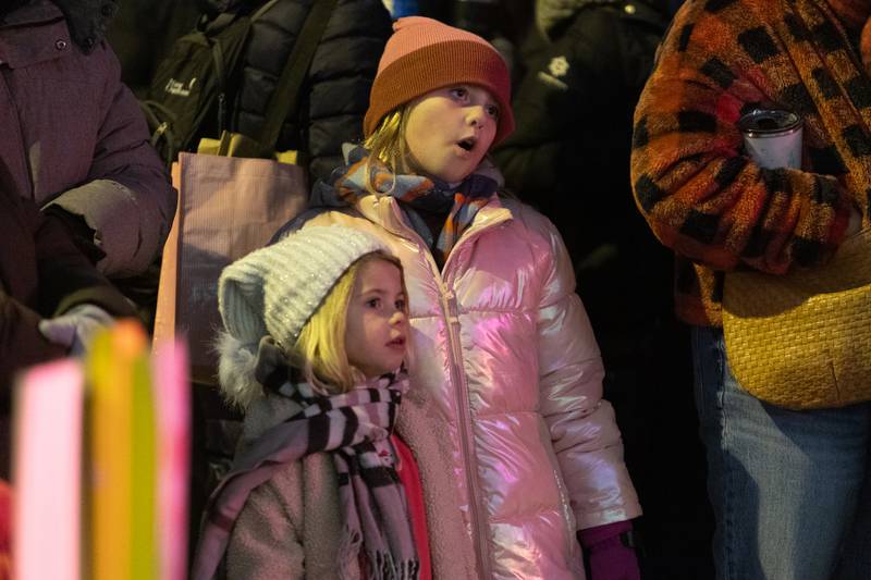Genevieve Neukirch (4) and Madden Neukirch (9) sing Christmas carols  at the Annual Geneva Christmas Walk on Friday, Dec. 5, 2025 in Geneva.