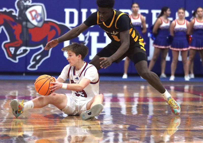 Jacobs’ Samson Averehi, right, guards Dundee-Crown’s Nathan Pederson in varsity boys basketball on Friday, Dec. 12, 2025, at Dundee-Crown High School in Carpentersville.