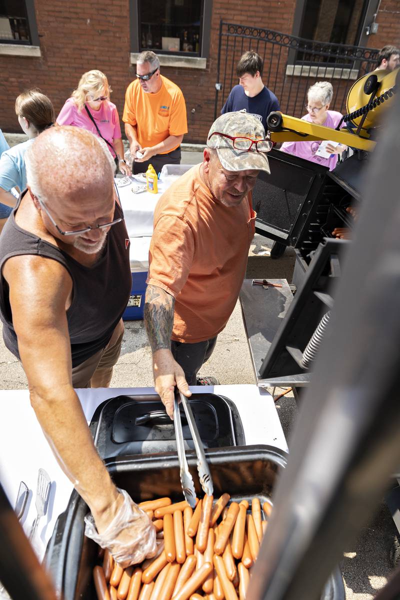 Bob Devers and Randy Covell cook up the hot dogs Friday, Aug. 1, 2025, on Light Street in Sterling for the annual Hot Dog Day.