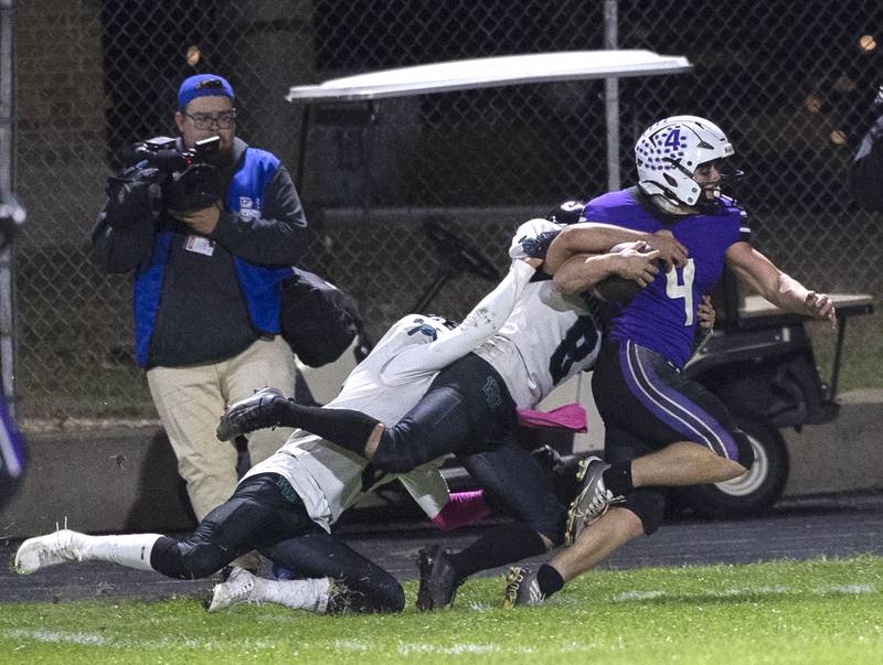 Dixon’s Landon Knigge is hauled down by a pair of Woodstock North players Friday, Oct. 31, 2025, in the Class 4A football first round playoffs.