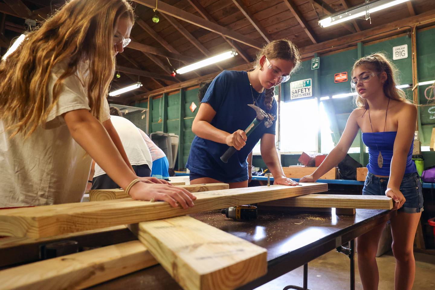 Vivian Gaskell, 15, center, of LaGrange Park, drives a bolt through part of her group's picnic table project during Tool Time at Camp Shaw-Waw-Nas-See on Wednesday, July 16, 2025.