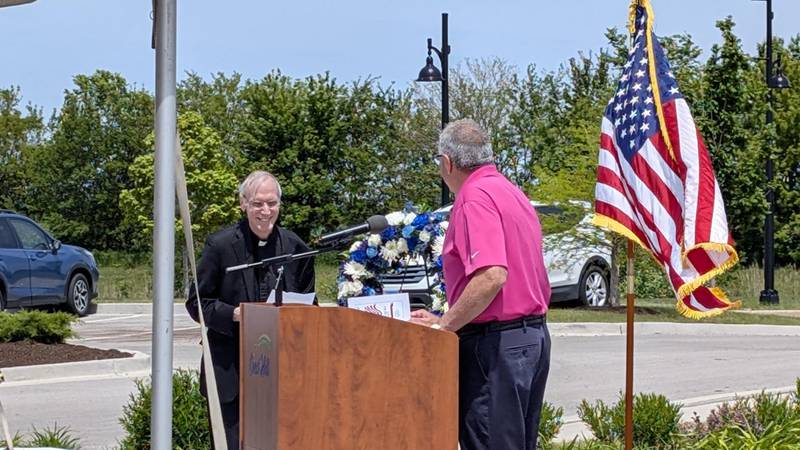The city of Crest Hill Veterans/Police Memorial Committee held its annual Memorial Day observance on Monday, May 26, 2025, at the Crest Hill Veterans/Police Memorial Garden. Crest Hill May Ray Soliman (right) welcomes Rev. Chris Groh, retired pastor, to the podium to give the invocation.