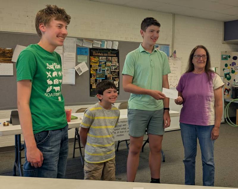 Lorna VanBrooklynn of the Merry Martha Club presents a donation to Kolton Motszko, Finn Slattery and David Wehler of the Leaf River Soaring Eagles  4-H Club.