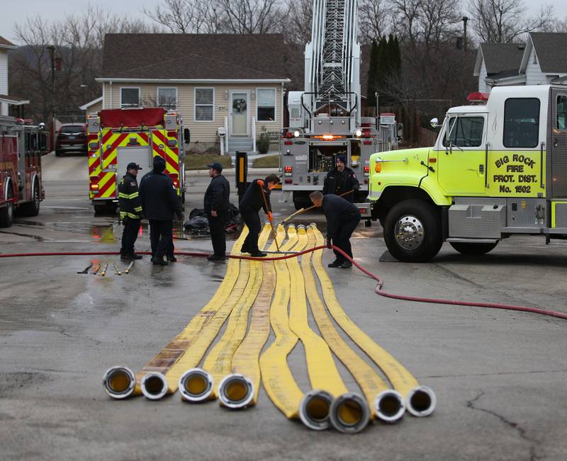 Firefighters from Aurora, Batavia, St. Charles and Big Rock fire departments wash down hoses used in the Carus Chemical fire on Thursday, Jan. 12, 2023 at the La Salle Fire Station