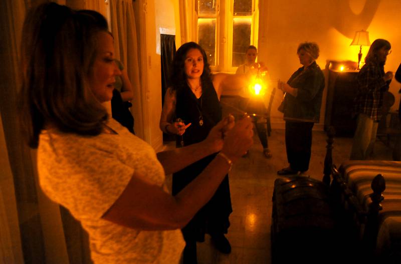 Loren Purcell, second from left, leads a paranormal tour Saturday, June 11, 2022, inside the Dole Mansion, 401 Country Club Road, in Crystal Lake. Purcell started offering the tours this spring in the mansion. She takes guests through the original building's three floors and offers historical anecdotes through the lens of spirit visitations while guests use pendulum crystals and dowsing rods as part of the tours for experiencing the visitations.