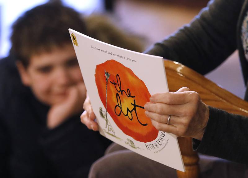 Bette Chwalisz, a retired teacher, holds the book “the dot”  on Thursday, Feb, 20, 2025, before she starts to read the book at Read Between The Lynes in Woodstock during the bookshop's weekly story time.