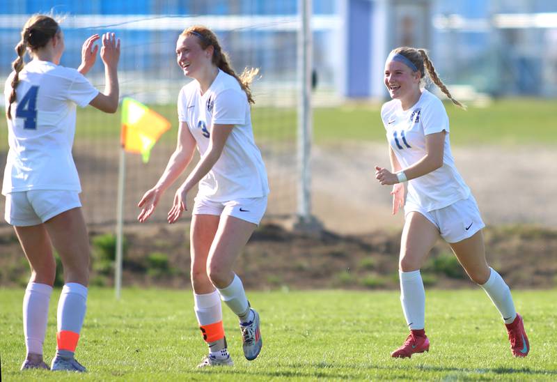 Woodstock’s Keira Bogott, center, celebrates the Blue Streaks’ second goal with teammates in varsity soccer on Wednesday, April 23, 2025, at Johnsburg High School in Johnsburg.