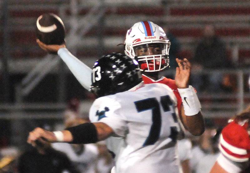 Ottawa quarterback Colby Mortensen throws past Woodstock North's Kayden Bracken at King Field on Friday, Sept. 29, 2023.