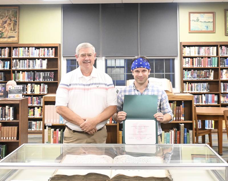 During Wednesday's board meeting, Director of Food and Nutrition Services Bobby Riahi stands with Board President Greg Sarver.