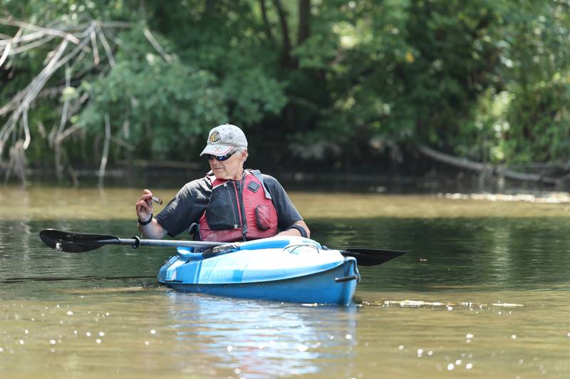 Greg Romaneck picks things up as he kayaks Thursday, Aug. 10, 2023, in the Kishwaukee River at the Knute Olson, Jr. Forest Preserve in Kingston. Romaneck has been making regular visits to pick up trash as he paddles the river and been an advocate for keeping the river and its surroundings free of pollution.