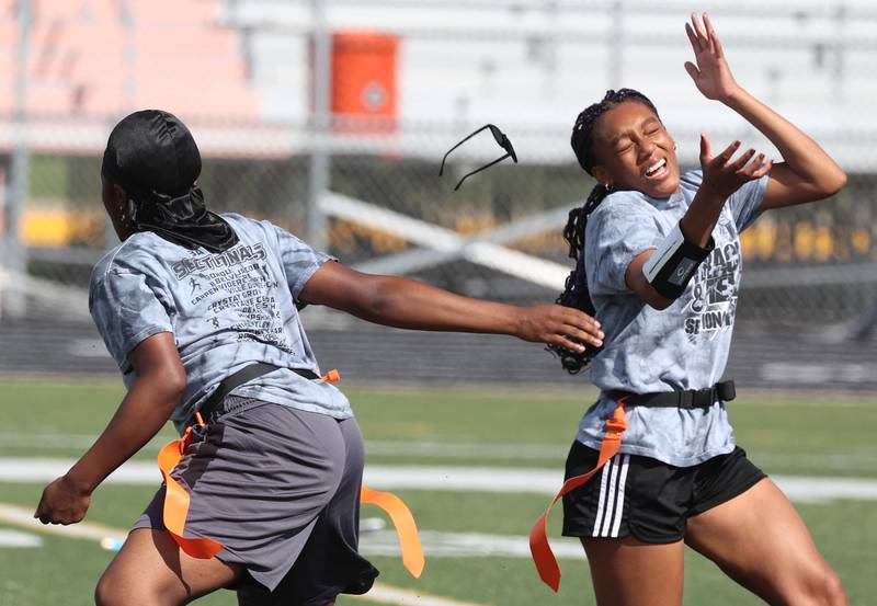 A player loses her glasses as she rushes the quarterback Wednesday, Aug. 20, 2025, during the first practice of the DeKalb High School flag football team. The squad is preparing for their inaugural season.