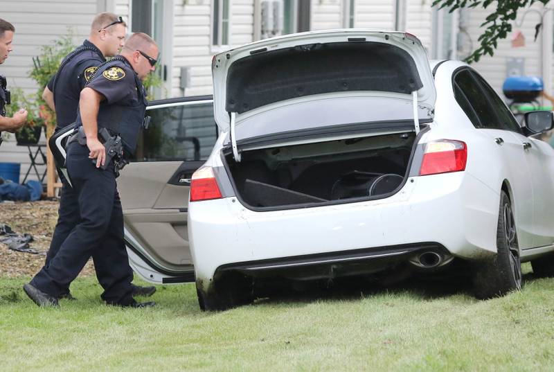 DeKalb County Sheriff's officers search a car that came to a stop in the grass behind Cambridge Square Townhomes off of Fotis Drive in DeKalb Monday, Aug. 29, 2022, after the driver led police on a chase through the area.