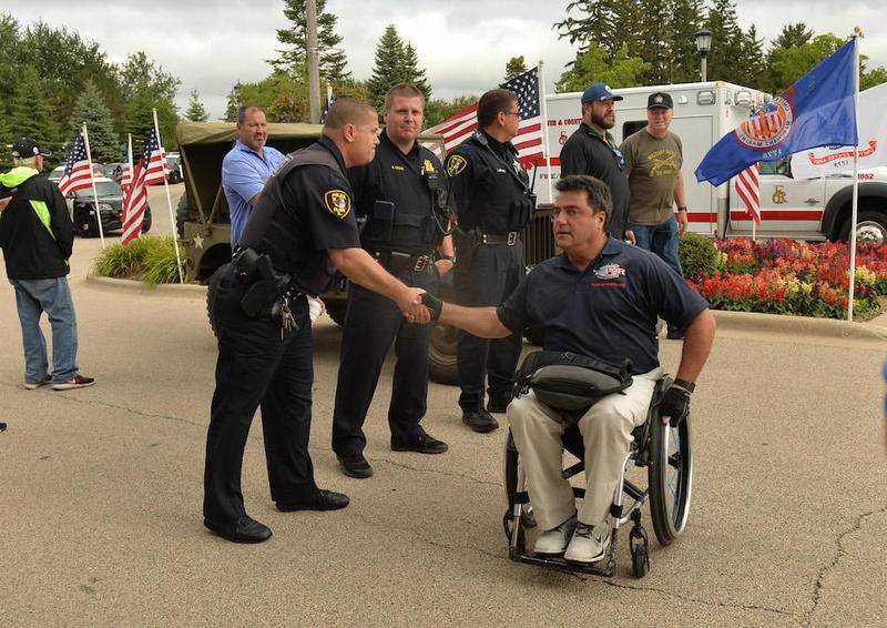 Special Forces veteran Anthony Netto of San Diego greets South Elgin police officers while arriving for a Warrior Wishes fundraiser at Royal Hawk Country Club in St. Charles July 24. The event benefits Operation Warrior Wishes, a non-profit that brings veterans to sporting events.  (Mary Beth Nolan for Shaw Media)