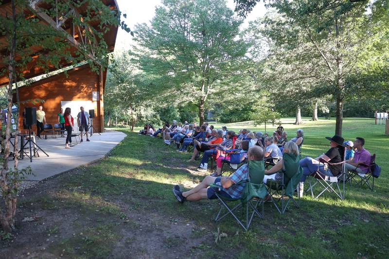 Dozens of residents line the band shell at Goold Park to watch the GreenRoom Improv show hosted by the Morris Library on Friday, Aug. 11, 2023 in Morris.
