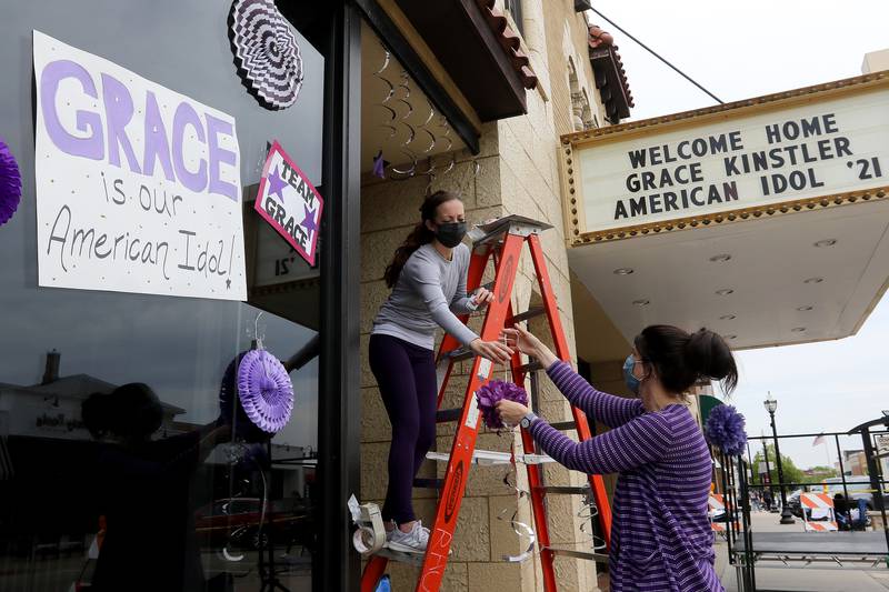 Tessa Burke, left, and Kristen Bennett, both of Crystal Lake, decorate the Raue Center for the Arts as they prepare for a parade through downtown Crystal Lake for Grace Kinstler, a Crystal Lake Central High School graduate and finalist on "American Idol," on Tuesday, May 18, 2021, in Crystal Lake.