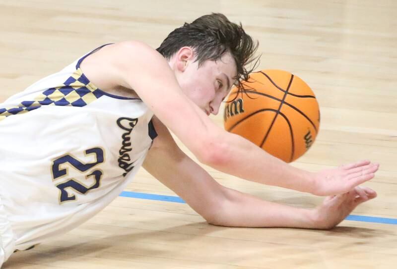 Marquette's Griffin Dobberstein dives for a loose ball against Earlville on Friday, Jan. 3, 2025 in Bader Gym at Marquette High School.