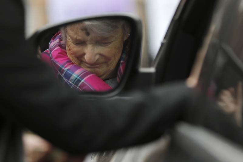 Mary Thillens reflected in the mirror of her car, prays with Rev. Jeffry Bross, the senior pastor at the United Methodist Church of Libertyville, during a Drive-Thru Ash Wednesday Blessing on Wednesday, March 05, 2025, at the United Methodist Church of Libertyville. This was the first time the church has offered a Drive-Thru Ash Wednesday Blessing, that created a simple convenient way for individuals to receive ashes and mark the beginning of the Lenten season.
