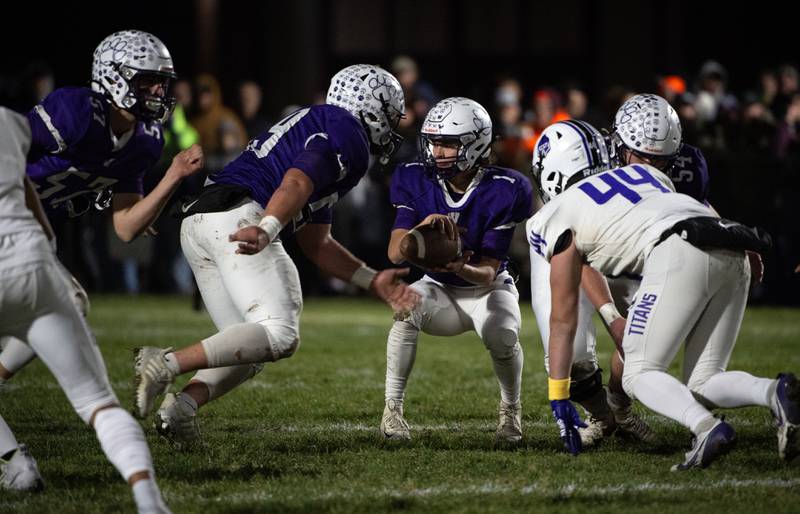 Wilmington's Billy Moore, center, looks to hand the ball off after receiving the snap in the Class 2A semifinal against El Paso-Gridley on Saturday, November 22, 2025.