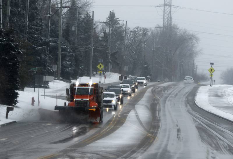 A Crystal Lake snowplow travels along Walkup Avenue near Veterans Acres Park as a winter storm moves through McHenry County on Tuesday, Jan. 9, 2024, delivering snow to most of the county.