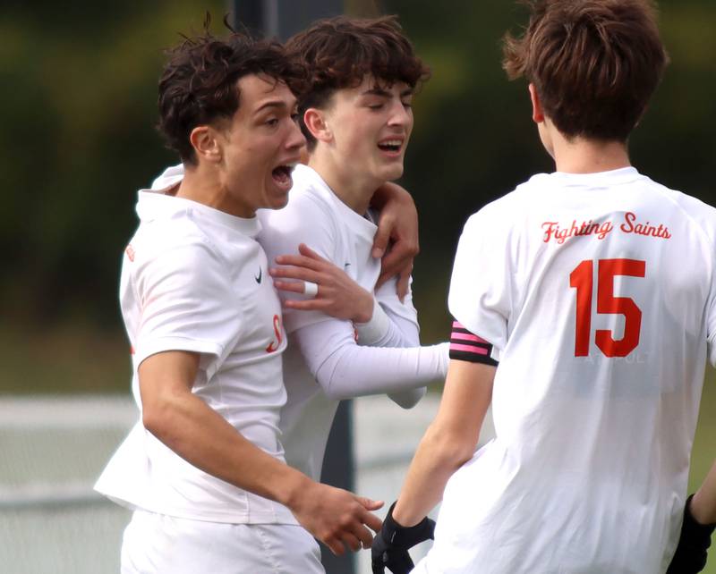 St. Charles East’s Sam Arville, center, is greeted by Huxley Kapoor, left, after an Arville goal in IHSA Class 3A Regional Championship soccer at Dundee-Crown High School in Carpentersville on Saturday, October 25, 2025.