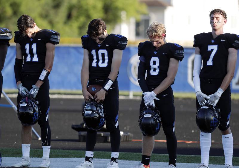 Highland Park's Nicholas Blumer (11) David Finfer (10) Sebastian Vybral (8) and Christian Billetdeaux (7) pause with their team doing a moment of silence Friday August 26, 2022 in Highland Park.