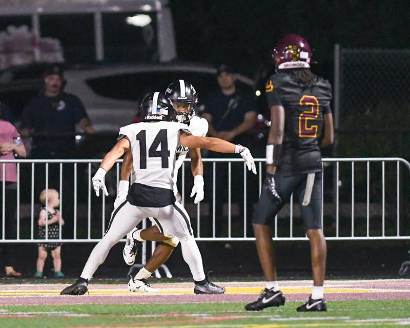 Fenwick's Raphiel Stewart (4) gets congratulated by teammate Fenwick's Cameron Garrett (14) after scoring a touchdown during the game on Friday Sept. 19, 2025, while traveling to take on Montini Catholic High School.