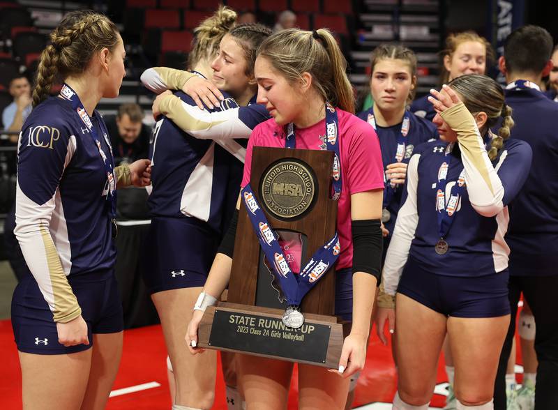 IC Catholic’s Ava Falduto holds the Class 2A State Runner-Up trophy among devastated teammates after their loss against Mater Dei in the Class 2A Volleyball Championship match on Saturday, Nov. 11, 2023 in Normal.