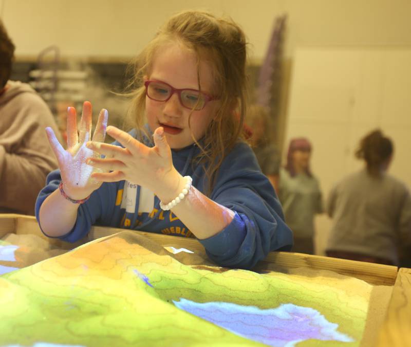 Ryland Maltas of DePue plays in geological glowing sand during the annual Scifest on Friday, April 21, at Illinois Valley Community College  in Oglesby.