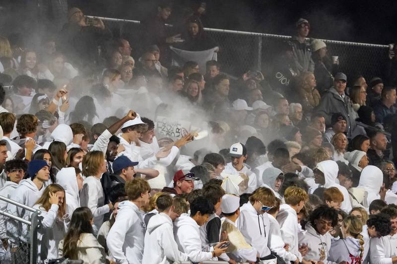 Oswego East’s student section throws white powder into the air prior to kick-off against Oswego during a football game at Oswego High School on Friday, Oct. 20, 2023.
