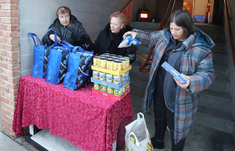 Stage Coach Players Outreach Committee members Deb Brubaker, (left) Jan Kuntz and Angela Schiola (right) sort donations and pack bags Tuesday, Nov. 15, 2022, while collecting donations at the theater in DeKalb for their Thanksgiving food drive. The group is working with the Salvation Army to put together Thanksgiving meals for local families in need.