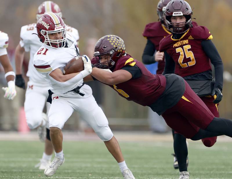 Morris' Anthony Smith (21) tries to avoid Montini's Johnny Louise (6) during the IHSA Class 4A semifinals football playoff game Saturday, Nov. 22, 2025 in Lombard.