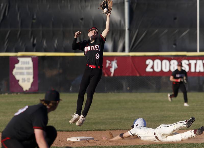 Huntley’s Aleks Gogola jumps to catch the throw to second base as Prairie Ridge’s Matthew McKim slides int the base during a Fox Valley Conference baseball game Wednesday, April 12, 2023, at Prairie Ridge High School.