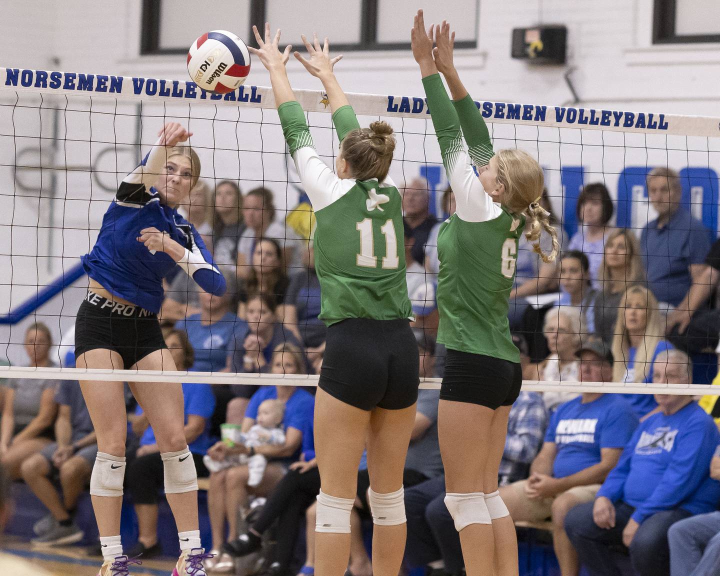 Adrianna Larsen of Newark spikes the ball past the reach of two Seneca's Graysen Provance and Franki Meyers during the match at Newark High School on September 9, 2024.