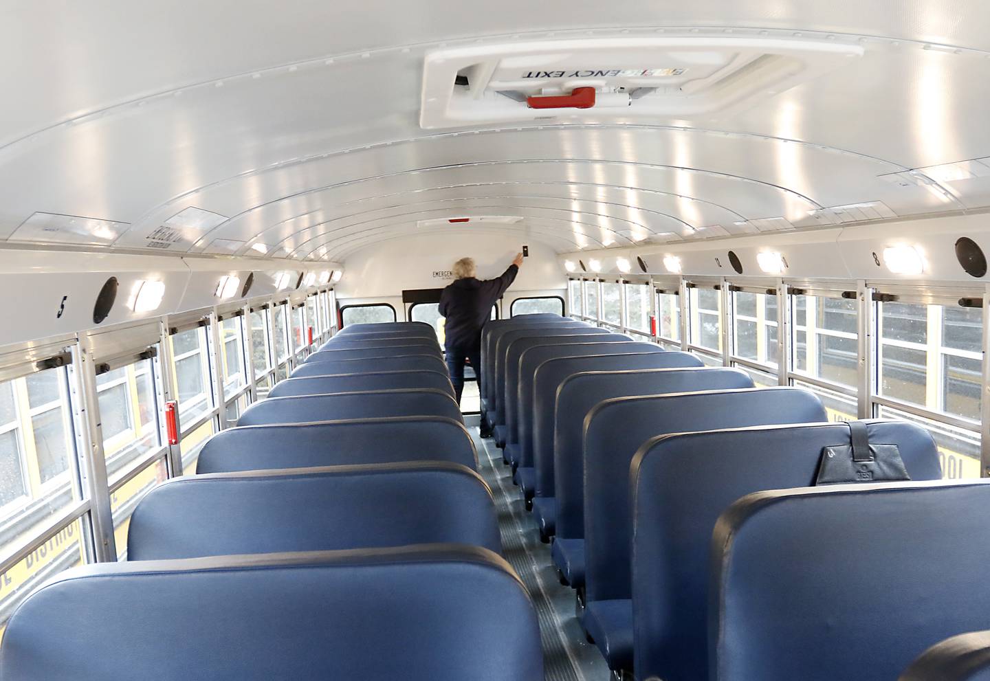 Bus driver Jane Srednicki does a safety check after parking one of Johnsburg School District 12's new school buses on Wednesday, Feb. 16, 2022. Before Johnsburg School District 12 stabilized its finances, the district could not afford to lease a brand-new fleet of school buses. These buses, which are 2022 models, were ordered over the summer and arrived in August. Getting to lease new meant that the district had more control of what direction it wanted to go, Director of Operations Tom Schwarz said, and so it decided to go with gasoline over diesel, which he said is better in terms of reliability and maintenance. That's one way the initial outlay may actually save the district money in the long term, he said. The district was also able to afford a longer five-year lease, which has a lower per-year cost. He said the district has also seen fewer behavioral issues with students vandalizing the buses now that they're nice and new.
